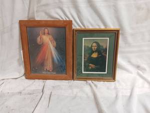 lot 33862 image: Two framed pieces of art a Divine Mercy print of Jesus Christ in a light brown wooden frame on the left, and a framed print of the Mona Lisa with a green mat on the right.