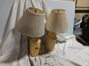 lot 33877 image: Pair of table lamps with beige or cream-colored ceramic bases and pleated, cone-shaped fabric shades.