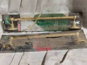 lot 33889 image: Set of two packaged wall-mounted brass towel bars with traditional round mounting plates and finials.