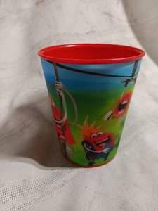 lot 33891 image: Plastic cup featuring cartoon graphics with a red rim and a blue-sky background.