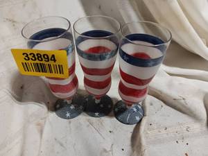 lot 33894 image: Decorative stemmed glasses featuring a patriotic red, white, and blue striped design with star accents on the bases