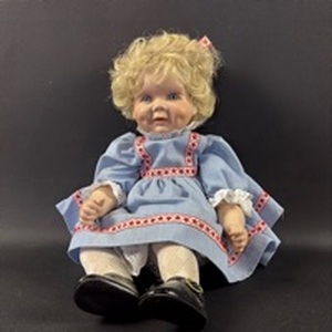 lot 42 image: Legacy Porcelain Doll with Blonde Curled Hair Blue Dress Red Trim Black Shoes