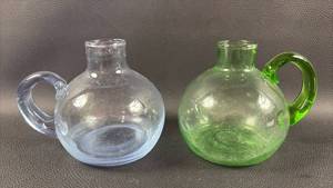 lot 52 image: Hand Blown glass mini pitchers or bud vases featuring round bodies and applied side handles 1) green 1) blue