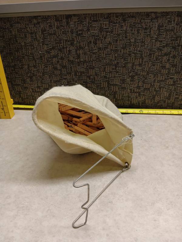 lot 1244 image: Wooden Clothespins with Wire Hooks Storage Bag