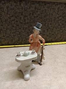 lot 1243 image: Porcelain Figurine Woman with Top Hat and Tea Set