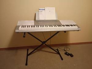 lot 915 image: Casio Keyboard with Stand.  On stand keyboard is 29 x 45.5 x 15.   Located in basement