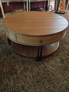 lot 946 image: Round Wooden Coffee Table.  One Drawer and a Bottom Shelf.  Top comes up.   17 x 38.