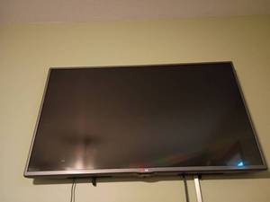 lot 953 image: 42in LG Television with Remote.  Still attached to wall.  Winner will have to bring tools and a ladder to remove