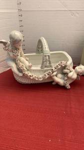 lot 1055 image: Antique porcelain or ceramic cherub basket planter featuring detailed floral garlands, reminiscent of late 19th- or early 20th-century Bohemian or Czech