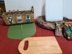 lot 1236 image: Oblong silicone casserole lid, fabric basket, Rubbermaid storage container, wicker basket and cutting board.