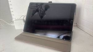 lot 1102 image: Apple iPad with Case and Power Adapter. Adapter is damaged as seen in photo.