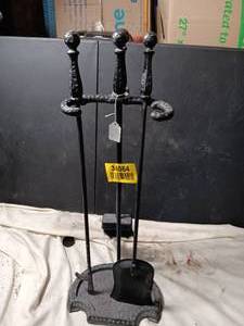 lot 34064 image: Black cast-iron fireplace tool set with a weighted base and ornate finial handles.