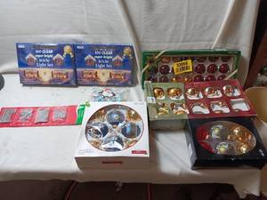 lot 33966 image: Holiday decorating supplies, including two boxes of clear icicle lights and several assorted boxes of classic and vintage-style glass Christmas ornaments.