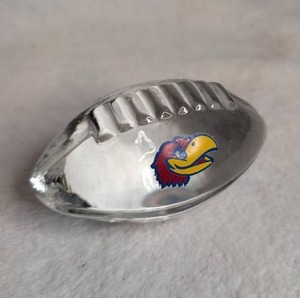 lot 3402 image: Clear Glass Kansas Jayhawks Football-Shaped Paper Weight
