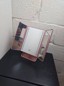 lot 121 image: Pink LED Tabletop Vanity Mirror with Fold-Out Panels and Stand untested