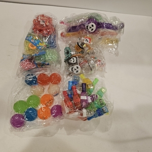 lot 2122 image: Halloween party favors and toys, including bouncy balls, mini whistles, slap bracelets, and skull rings
