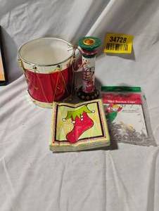lot 34728 image: Bundle of Christmas items including napkins, candle holder, Christmas drum decoration, and window suction cup hooks for lights
