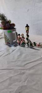 lot 34723 image: Christmas coffee mug, with Christmas scene figurines, and small table decor of ornaments and greenary