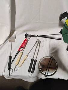 lot 34779 image: Grilling utensils, including 2 sets of tongs, grilling skewers, a spatula, and a long-stem lighter