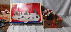 lot 34963 image: Lemax, Here comes Santa table setting, box of variety Christmas decor, vintage french horn, variety of christmas ornaments, christmas bells door hang