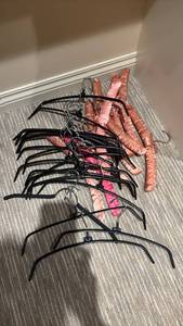 lot 1438 image: Black Rubber Clothes Hangers with Pink and Red Padded Hangers
