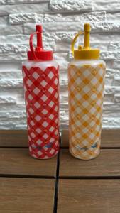lot 128 image: Dolly Parton 2 Condiment Bottles (Red & Yellow) w Gingham Butterfly