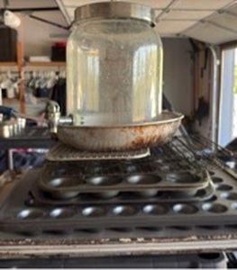 lot 141 image: Lot of Baking Pans Sheet Pans Mini Muffin Tins and Glass Jar with Tap Dispenser
