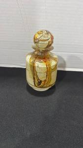 lot 1010 image: Art glass bottle featuring an earthy brown and tawny yellow swirl pattern with a matching ball stopper 6 inches tall