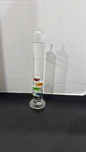 lot 1012 image: Glass Galileo thermometer featuring a vertical column filled with colorful floating spheres 15.5 inches tall