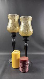 lot 213 image: Pair of Glass Candle Holders with Scrollwork Pattern and Candles 17.5 and 19 Inches Tall