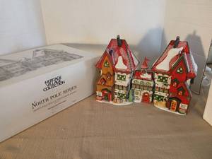 lot 1051 image: Heritage Village Collection North Pole Series Northpole Dolls and Santa Bear Works Handpainted Porcelain Buildings 3 Piece Set