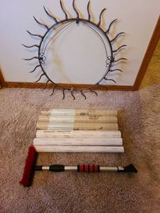 lot 7197 image: Round metal wall decor, 27in diam, wallpaper rolls, ice scraper