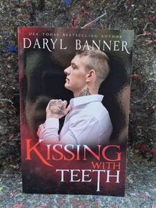 lot 100 image: Kissing With Teeth by Daryl Banner Paperback Book