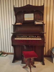 lot 909 image: Antique Crown Organ.  Made by Geo. P. Bent Chicago ILL USA. With Stool and Music Books.  Organ is 78 x 46 x 23.  Stool 18 x 13 x 13.   Located in basement