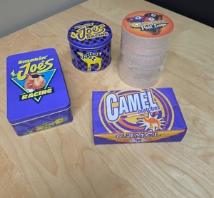 lot 77 image: Camel Cigarettes Collectibles Lot - Smokin Joes Racing Tin with match books inside, Camel Matches Box, Camel Pool League coasters, and another package of matches