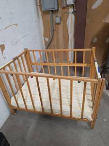 lot 305 image: Vintage MCM Wooden Baby Crib with colorful ball accents and Mattress, has drop down side (missing 1 caster)  28 W x 42 D x 29 H- not up to code for current day use - could use for displaying baby dolls