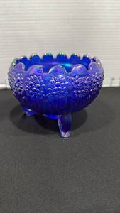 lot 1000 image: Fenton blue carnival glass three-footed bowl featuring a vibrant iridescent finish and a scalloped rim 4x5 dia