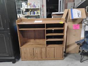 lot 35178 image: Wooden entertainment center with oak finish, large open shelf for a TV, a right-side stack of open shelving compartments, an upper shelf, and four lower cabinet doors for concealed storage