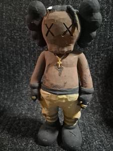 lot 66 image: Figurine Doll with Black Head Large Ears Tan Body Yellow Pants