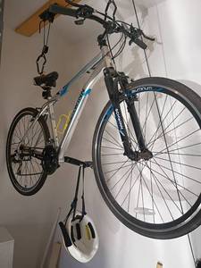 lot 955 image: Schwinn Aluminum Bicycle with Helmet and Bike Hoist.   The winner will need to bring a ladder and tools to remove it from the ceiling and wall