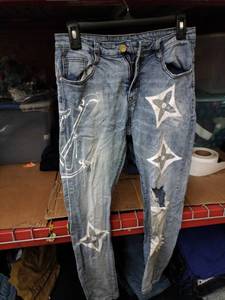lot 515 image: Louis Vuitton Motif Light Wash Distressed Denim Jeans with Painted Flower Motifs and Daisy Pocket
