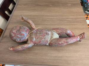 lot 66 image: Horror Prop Baby Doll Figure with Distressed Paint and Twine Detail