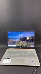 lot 22 image: HP laptop with 13-inch display. Rose gold chassis with silver keyboard. Intel processor visible on palm rest. Power cord included. Needs Factory Reset