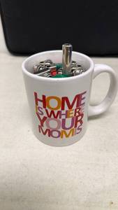 lot 97 image: Home Is Where Your Mom Is Ceramic Mug full of Disposable Lighters