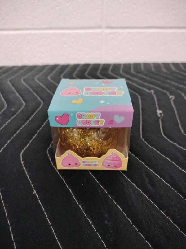 lot 141 image: Brady Budeey Gold Glitter Poop Emoji Squishy Toy in Display Box