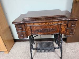 lot 825 image: Antiquevintage White Family Rotary treadle sewing machine with 2 boxes of attachments. 30x33x18, located in basement.