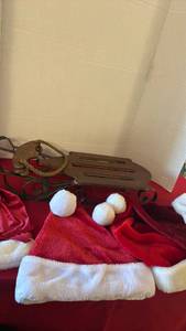 lot 1215 image: Small wooden and metal decorative sleigh and Santa hats 22x5