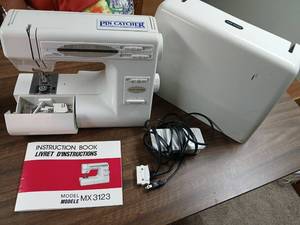 lot 2204 image: New Home MX3123 Sewing Machine with Pin Catcher,Carrying Case, footpedle , and Accessories located in basement