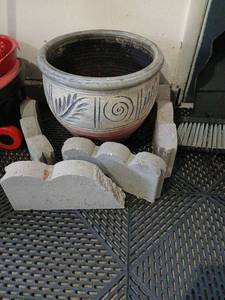 lot 3500 image: Decorative Ceramic Planter Pot  15 in  diameter 13 tall, with four concrete edging pieces located in garage