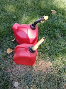 lot 5001 image: Red Fuel Cans with Yellow Spout  2gal partial full, 1 gal empty with extra nozzle